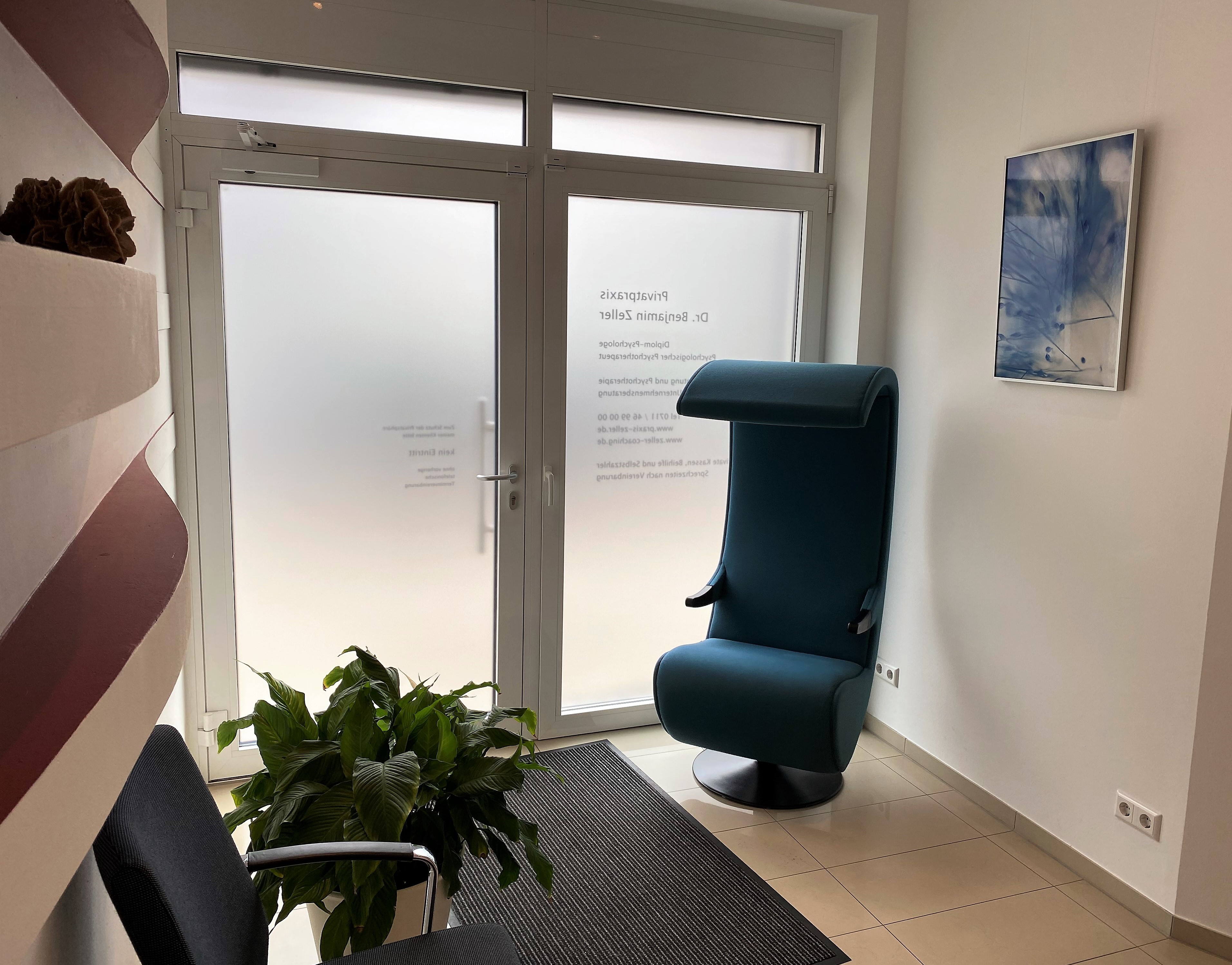 Empfangsbereich mit Sesseln und Glastür